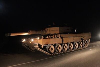 A tank, part of a convoy of Turkish military vehicles is pictured near the rebel-held northern Syrian border town of al-Rai on December 25, 2018.  Turkey over the weekend sent military reinforcements to the the border with Syria, with parts of the convoy entering Syria in areas held by Turkish-backed Syrian rebels. / AFP / Aref TAMMAWI
