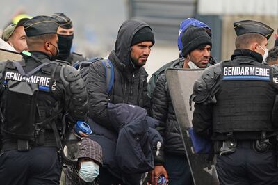 Migrants wait in France to cross into Britain while French police oversee their movements. PA