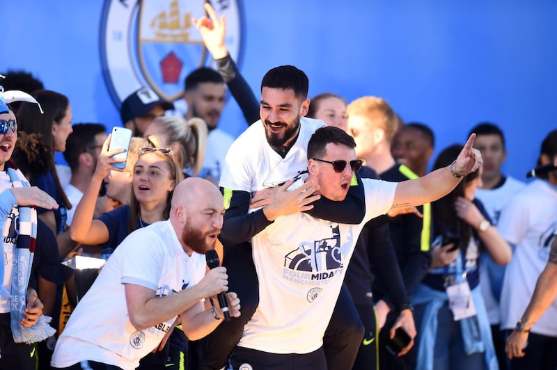 Ilkay Gundogan of Manchester City celebrates on stage with backroom staf. Getty Images