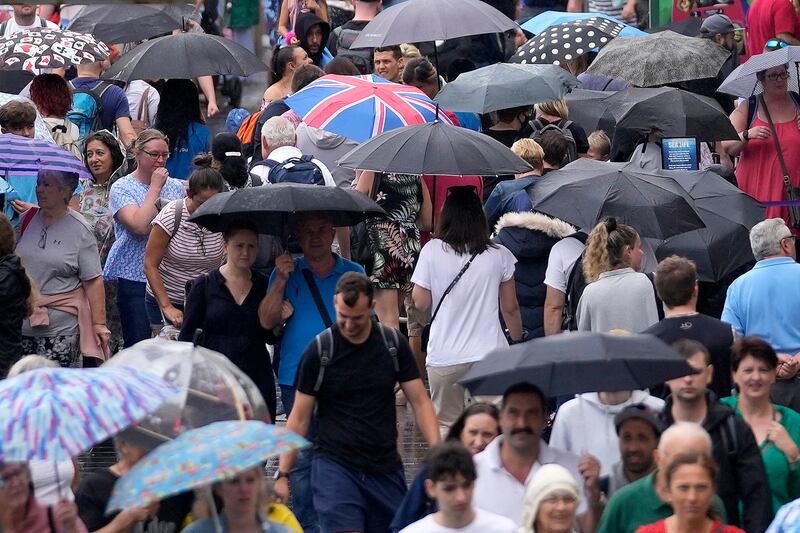 Tourists in London. The Met Office has issued a yellow thunderstorm warning for England and Wales. AP