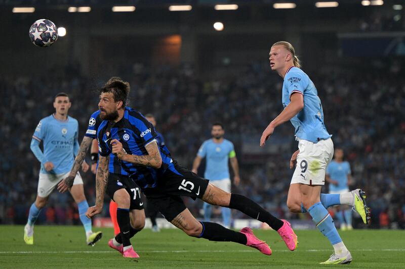 Manchester City striker Erling Haaland watches as Inter Milan's Francesco Acerbi heads the ball clear. AFP