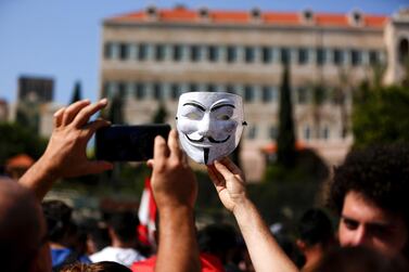 Lebanese demonstrators taking a picture of a Guy Fawkes mask during a protest in front of the Grand Serail in downtown Beirut as protestors continued to gather in the country for a third day against tax increases and alleged official corruption after the security forces made dozens of arrests.  AFP