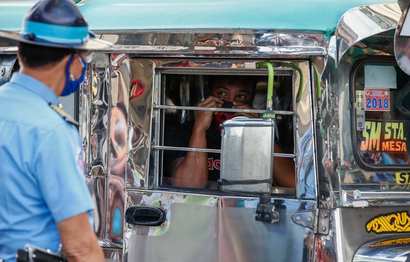 A passenger of a minibus, locally known as jeepney, looks out at a transportation bureau officer in Quezon City, Metro Manila, Philippines.  EPA