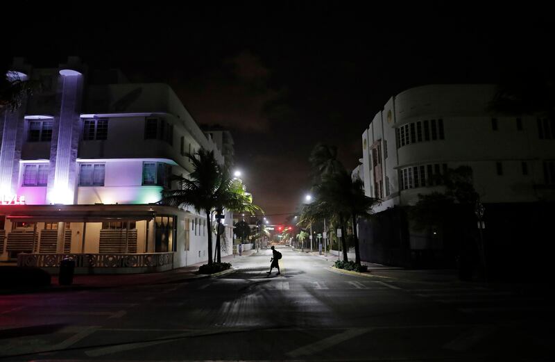 A lone pedestrian walks through the usually bustling South Beach ahead of Hurricane Irma in Miami Beach. Florida has asked 5.6 million people to evacuate ahead of Hurricane Irma, or more than one quarter of the state's population, according to state emergency officials. David Goldman / AP Photo
