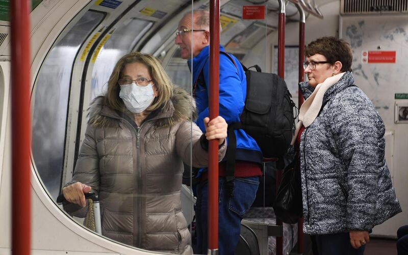 A woman wears a protective face mask aboard an underground train in London, 06 March 2020.  Andy Rain / EPA