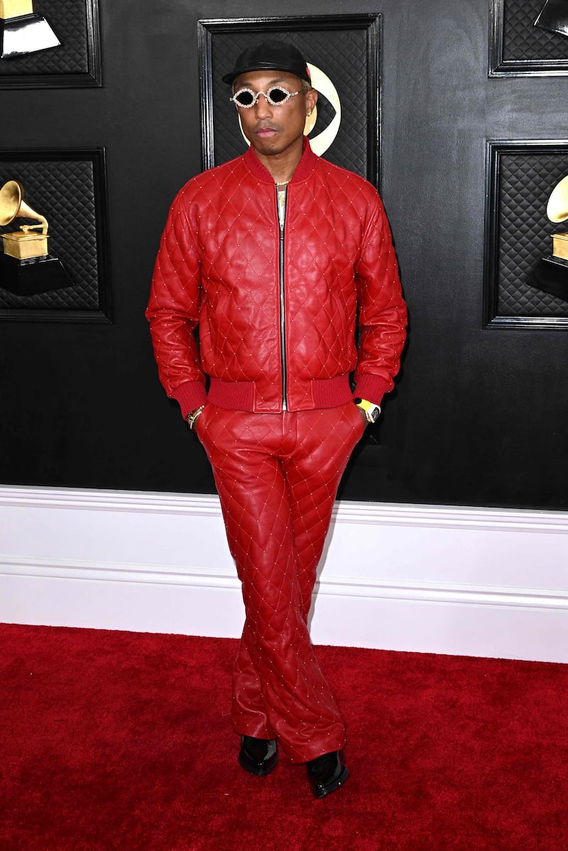 Pharrell Williams wears a studded red leather bomber jacket with matching trousers by Ernest W Baker. AFP