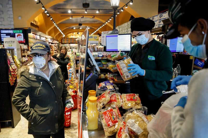 Sandra Perez, left, purchases goods at a grocery store she intends to donate to needy families, in the Harlem neighborhood of New York.  AP