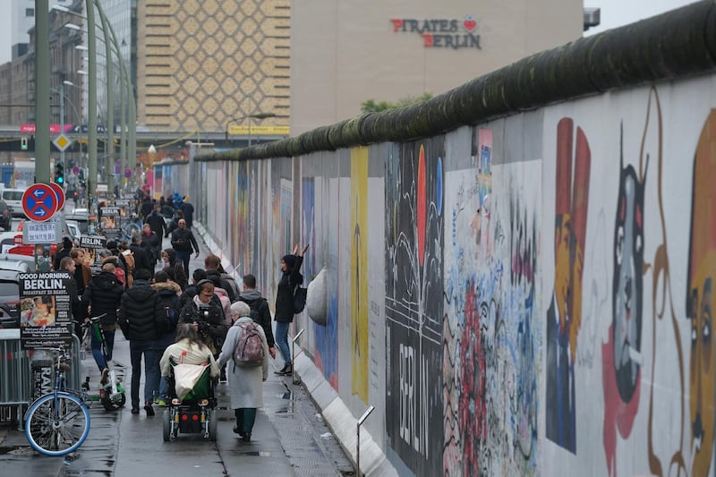 Visitors walk along a still-standing section of the former Berlin Wall called the East Side Gallery in Berlin, Germany. At least 136 people, many of them shot dead by East German border guards, were killed trying to escape. Getty Images