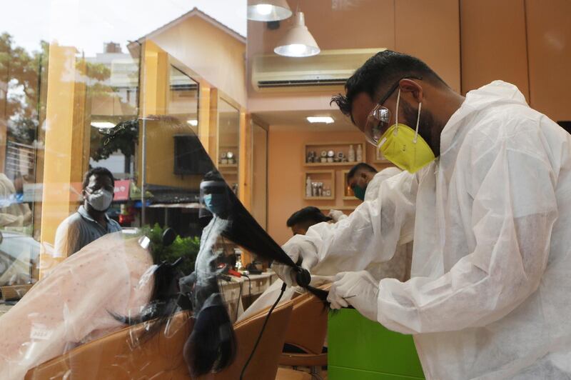 A hairstylist works on a customer's hair in Mumbai, India. AP Photo