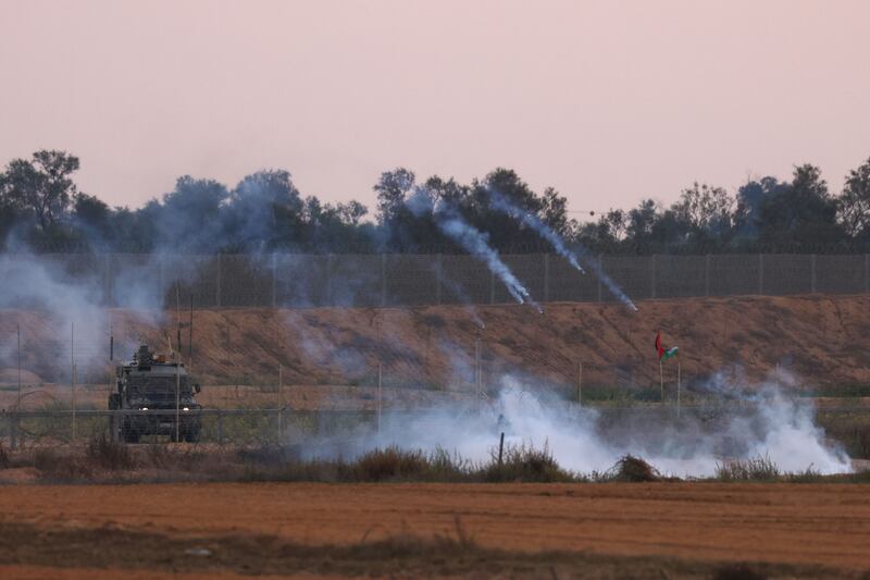 Israeli forces fire teargas towards Palestinian protesters during clashes near the Israel-Gaza border fence on Friday. AFP
