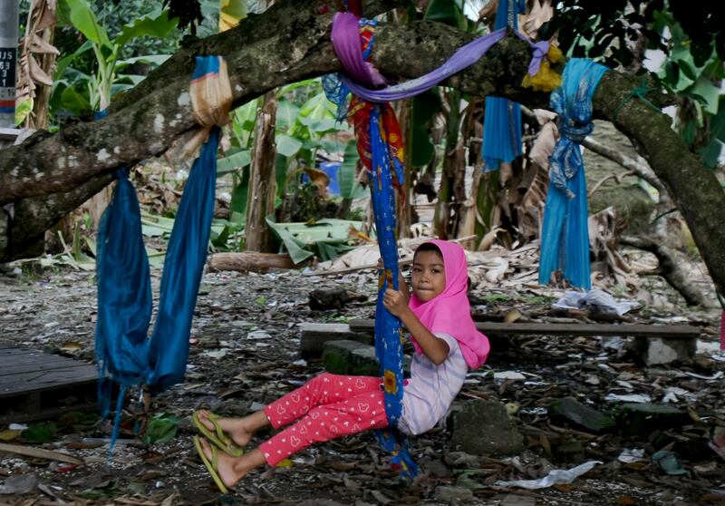 A Rohingya Muslim girl living in Malaysia sits on a makeshift swing outside her house in Klang, outside Kuala Lumpur, Malaysia. There are some 56,000 Rohingya refugees registered with the UN refugee agency in Malaysia. Daniel Chan / AP Photo