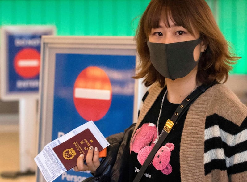 Passengers wear protective masks as they arrive at the Los Angeles International Airport, California, USA. AFP