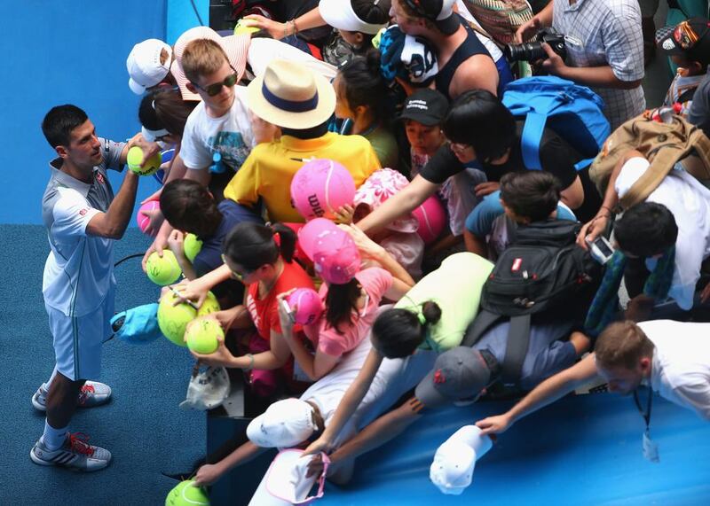 Novak Djokovic of Serbia signs autographs after winning in his second round match against Leonardo Mayer of Argentina during day three of the 2014 Australian Open at Melbourne Park. Quinn Rooney / Getty Images
