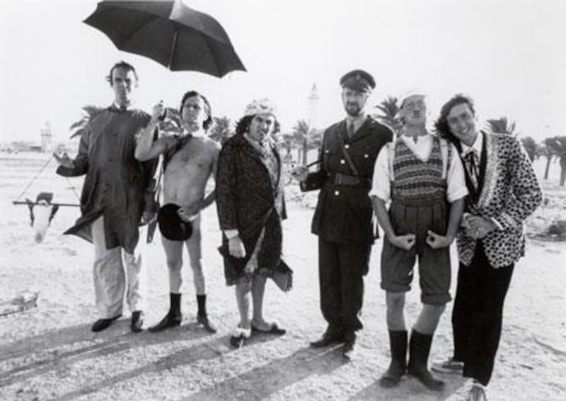 The cast members of the original Monty Python's Flying Circus line up on a beach. From left to right, John Cleese, Terry Gilliam, Terry Jones, Graham Chapman, Michael Palin and Eric Idle.