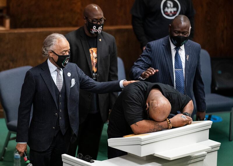 Terrence Floyd, brother of George Floyd who died in the custody of white police officers, breaks down during a prayer service at Greater Friendship Missionary Church, as Rev Al Sharpton, left, his brother Philonise Floyd and lawyer Ben Crump, right, try to console him, on Sunday, March 28, 2021, in Minneapolis. AP