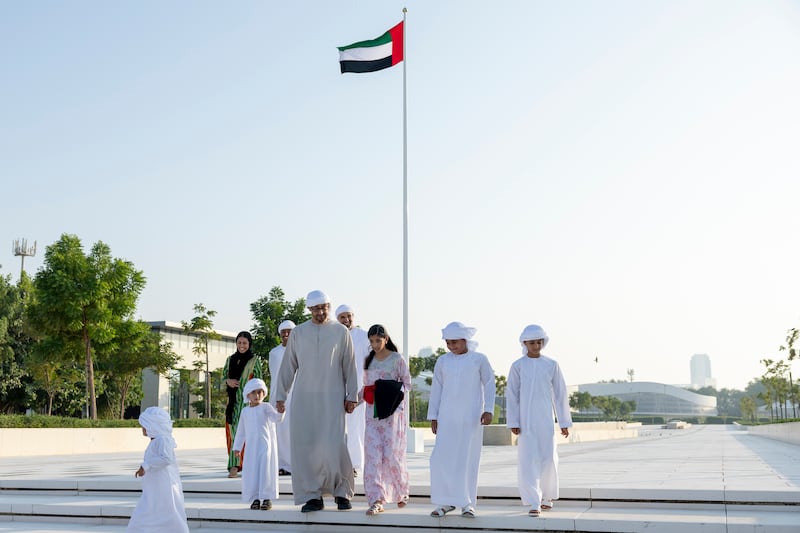 President Sheikh Mohamed walks with his grandchildren at the Sea Palace before Flag Day. Seen with Sheikh Khaled bin Mohamed, member of the Abu Dhabi Executive Council and chairman of the Abu Dhabi Executive Office. Photo: UAE Presidential Court