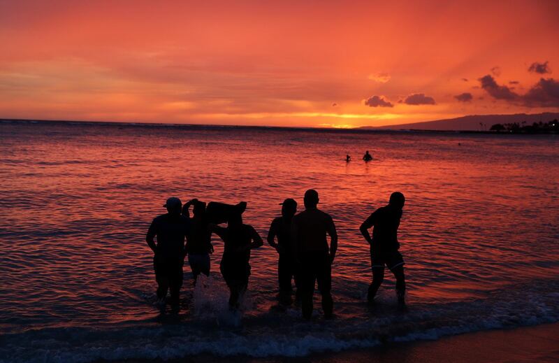 People watch the sunset on Waikiki Beach ahead of Hurricane Lane in Honolulu. John Locher / AP Photo