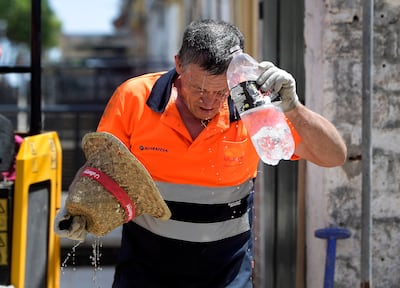 A worker in Sevilla, southern Spain, cools off as a heatwave continues to sweep across parts of Europe. AFP