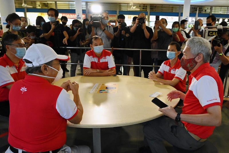 Lee Hsien Yang, right, chats with Tan Cheng Bock, left, at the Tiong Bahru Market in Singapore on Sunday. AFP