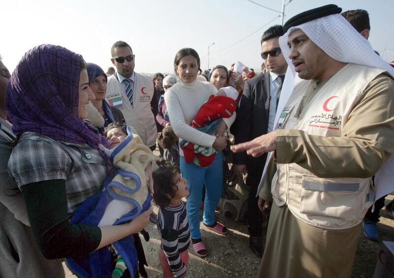 Rashid Al Mansuri, Consul General of the UAE to Arbil, visits Syrian-Kurdish refugees as aid is distributed by the Emirates Red Crescent at the Quru Gusik refugee camp. Safin Hamed / AFP Photo

