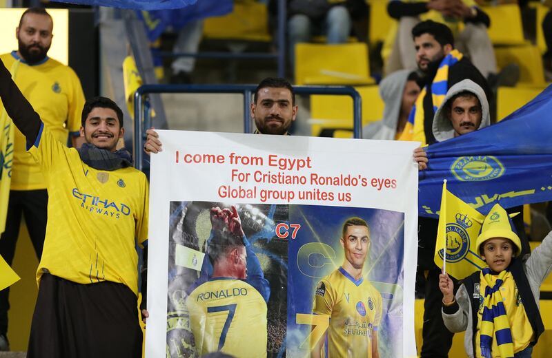 A fan of Al Nassr's holds up a Cristiano Ronaldo poster before the match. Reuters