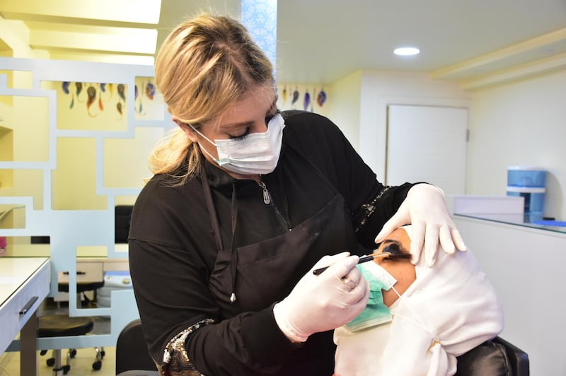 Female worker wearing masks and gloves works in teauty salon in one of the neighborhoods of Damascus, Syria. EPA