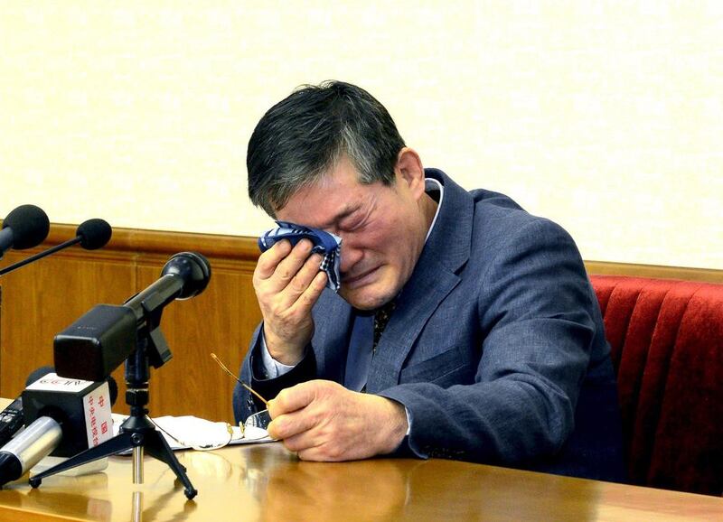 A man, who identified himself as Kim Dong Chul, previously said he was a naturalised American citizen and was arrested in North Korea in October, cries during a press conference in Pyongyang. KCNA / Reuters