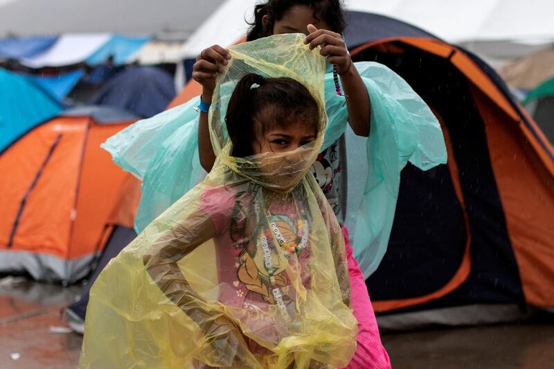 A migrant girl, part of a caravan of thousands from Central America trying to reach the United States, wears a raincoat to protect from rainfall at a temporary shelter in Tijuana, Mexico. Reuters