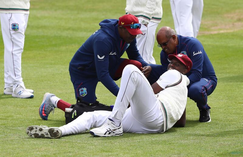 West Indies captain Jason Holder receives treatment after injuring his thumb trying trying the catch the ball. AP