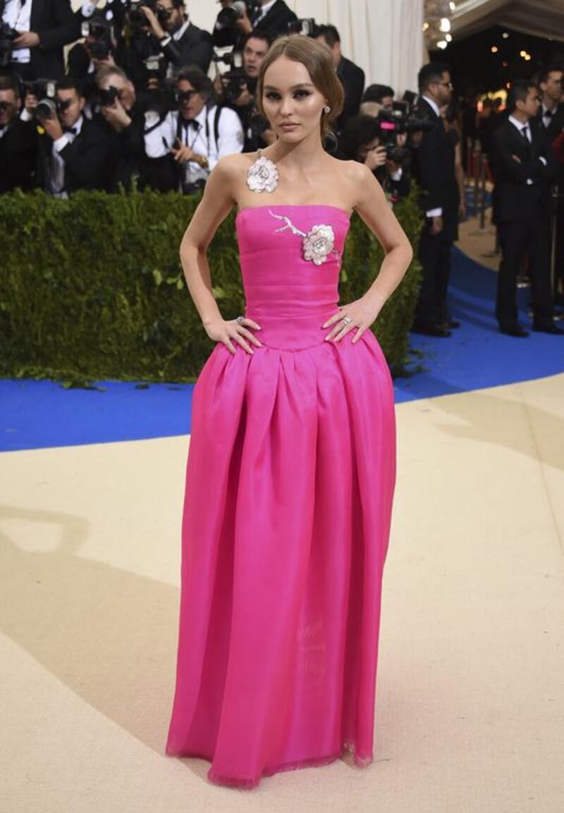 Lily-Rose Depp is a vision in hot pink, dressed in a Chanel gown adorned with metallic floral appliqués. Evan Agostini / Invision / AP