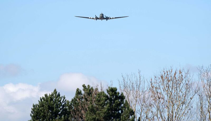 A Dakota plane flies past during the funeral service. AFP