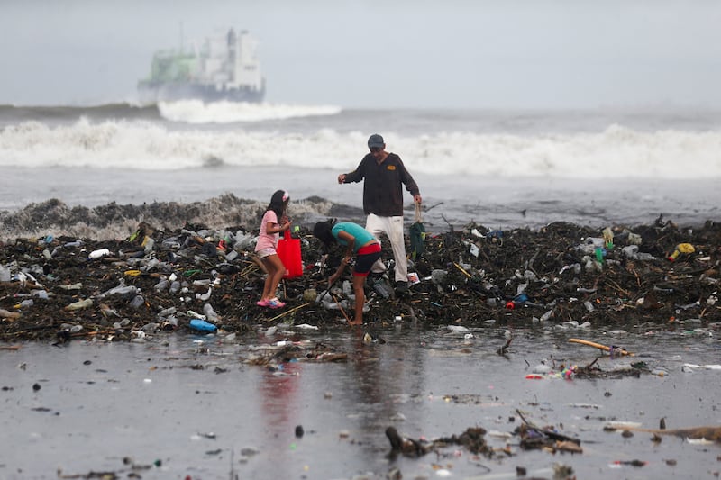 People collect recycling after heavy storms washed rubbish on to a beach in Acajutla, El Salvador. Reuters