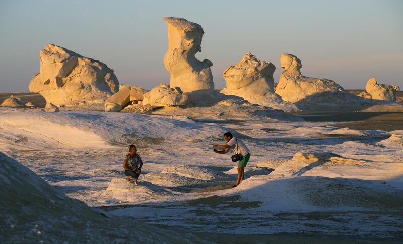 Tourists pose for pictures in front of the massive white inselbergs that are characteristic of Egypt's White Desert. EPA