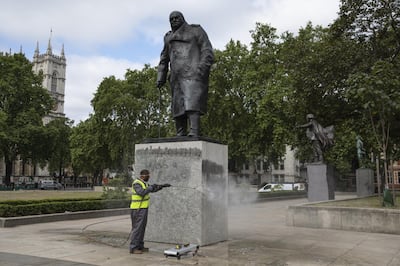 LONDON, ENGLAND - JUNE 08: A worker cleans the Churchill statue in Parliament Square that had been spray painted with the words 'was a racist' on June 08, 2020 in London, England. Outside the Houses of Parliament, the statue of former Prime Minister Winston Churchill was spray-painted with the words "was a racist" amid anti-racism protests over the weekend. In Bristol, protesters toppled a statue of Edward Colston, a 17th-century slave-trader, and tossed it into the harbor. (Photo by Dan Kitwood/Getty Images)