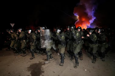 Ukrainian law enforcement officers clear the way as demonstrators block a road during a protest against the arrival of a plane carrying evacuees from coronavirus-hit China. Reuters