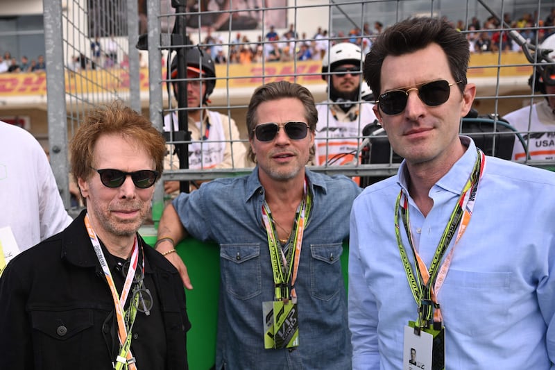 Film producer Jerry Bruckheimer, left, actor Brad Pitt and film director Joseph Kosinski await the start of the Formula One United States Grand Prix. AFP
