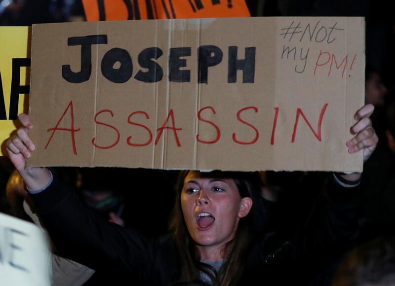 A protester holds a sign during a protest outside the Government Palace. Reuters