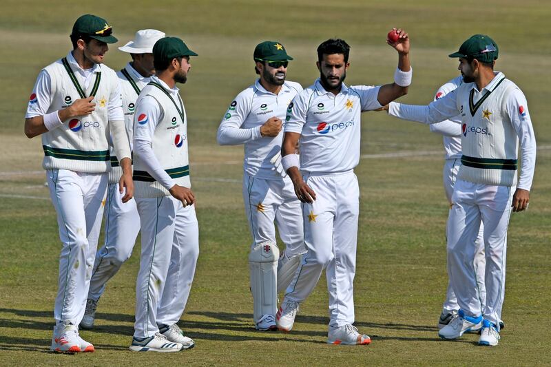 Pakistan's Hasan Ali holds the ball as his teammates congratulate him after he took five wickets at the end of the South Africa's innings during the third day of the second Test cricket match between Pakistan and South Africa at the Rawalpindi Cricket Stadium in Rawalpindi on February 6, 2021.  / AFP / Aamir QURESHI
