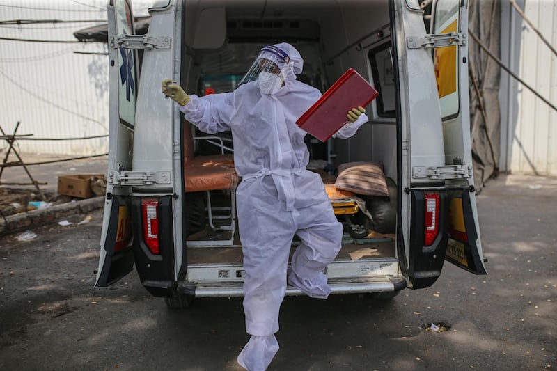 A health worker exits an ambulance outside a quarantine center at the Goregaon NESCO jumbo Covid centre in the Goregaon suburb of Mumbai, India, on Tuesday, April 27, 2021. India's spike in virus numbers has prompted state governments to impose movement curbs, which in turn have tamped down economic activity as well as stoked price pressures because of broken supply chains. Photographer: Dhiraj Singh/Bloomberg