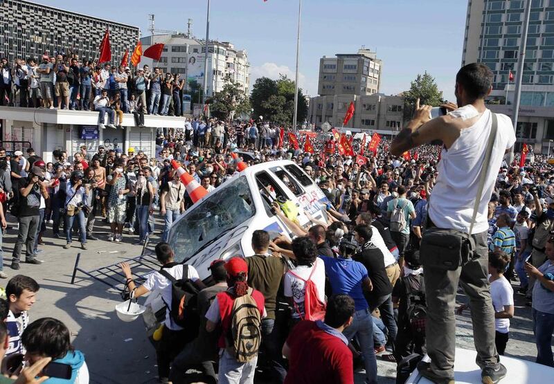 Protesters prepare to roll a police car over during an anti-government protest at Taksim Square in central Istanbul in June. Murad Sezer / Reuters