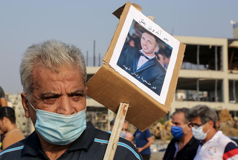 Families of Beirut port explosion victims carry their pictures during a minute of silence and prayer to mark one month of Beirut port explosion. EPA