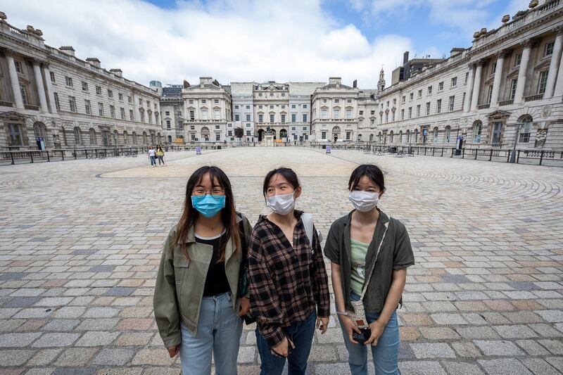 LONDON, ENGLAND - JULY 16: Visitors wearing masks pose for a photo in the courtyard during the reopening of Somerset House on July 16, 2020 in London, England. As the country further emerges from the COVID-19 lockdown, galleries and museums such as this are once more opening their doors to the public, albeit with certain guidelines and conditions in place, to protect the health of visitors. (Photo by Tim P. Whitby/Getty Images)