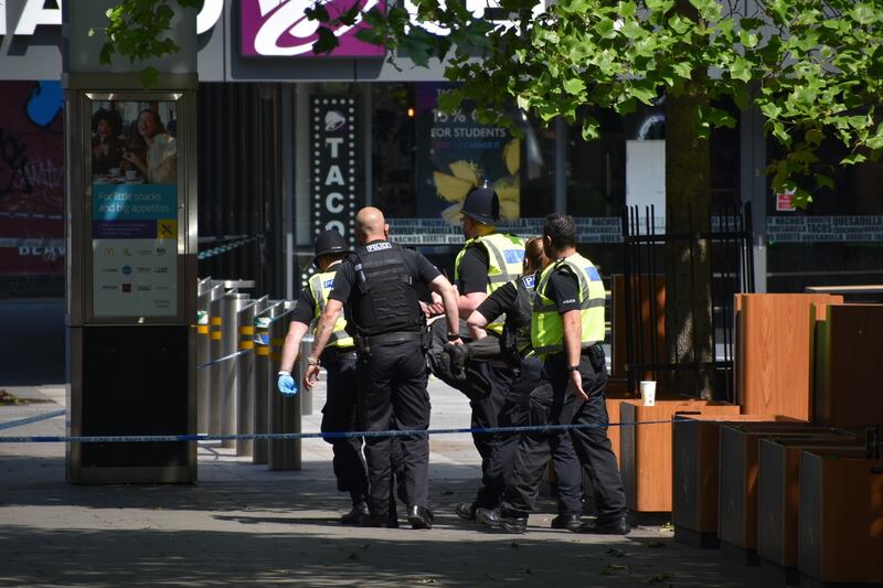 Officers remove a person who had entered the police cordon on Milton Street. PA