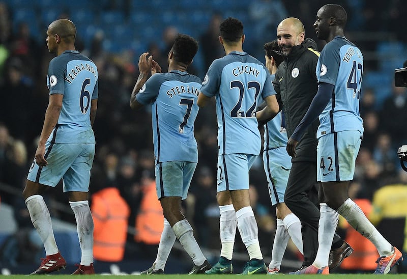 Manchester City's Spanish manager Pep Guardiola (2R) congratulates his players following the English Premier League football match between Manchester City and Arsenal at the Etihad Stadium in Manchester, north west England, on December 18, 2016. - Manchester City won the match 2-1. (Photo by Oli SCARFF / AFP) / RESTRICTED TO EDITORIAL USE. No use with unauthorized audio, video, data, fixture lists, club/league logos or 'live' services. Online in-match use limited to 75 images, no video emulation. No use in betting, games or single club/league/player publications. / 