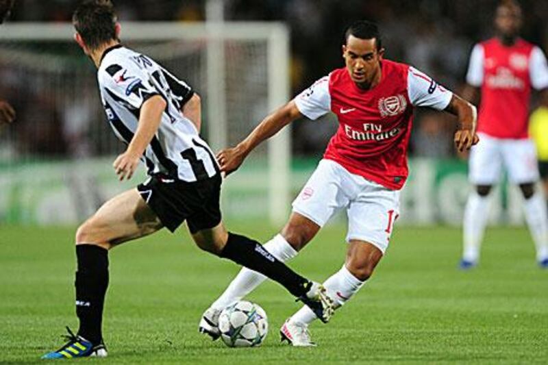 Theo Walcott, right, dribbles pass the Udinese defender Neuton. Walcott's 69th minute goal sealed the tie for the English club.