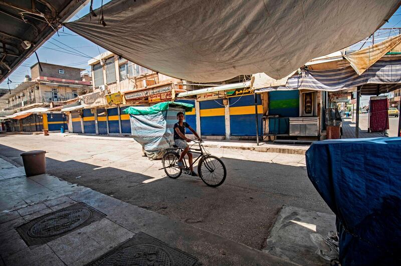 A young boy rides a bicycle in front of closed shops in the Kurdish-majority city of Qamishli of Syria's northeastern Hasakeh province. AFP