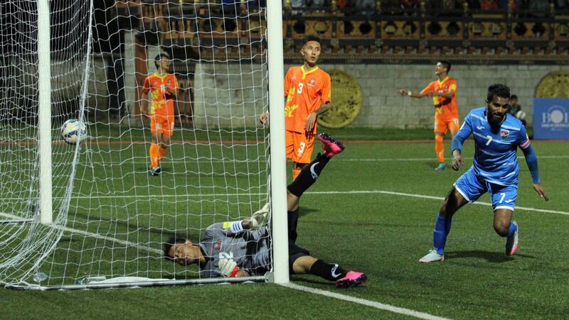 Ali Ashfaq from the Maldives (R) scores the team's second goal against Bhutan's goalkeeper H. Gurung (C) during the FIFA 2018 Asian Group C qualifying football match between Bhutan and Maldives at The Changlimithang Stadium in Thimphu on October 8, 2015. AFP PHOTO / Upasana DAHAL (Photo by UPASANA DAHAL / AFP)