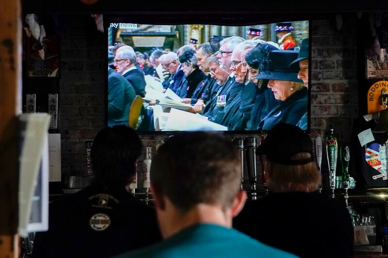 Patrons watch a replay of the funeral at Ye Olde King's Head. EPA