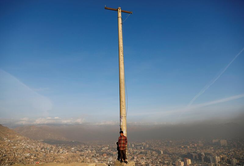 An Afghan boy stands in the sun on a hilltop overlooking Kabul. Reuters