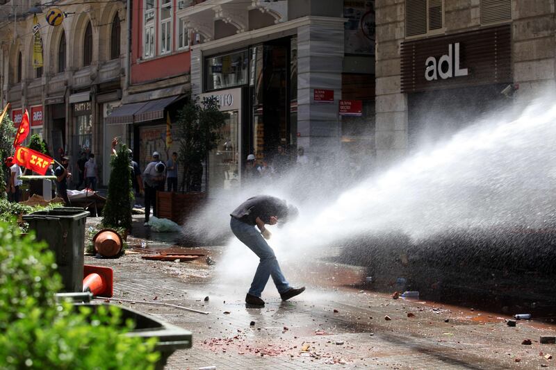 TOPSHOTS-Police use a water cannon to disperse protestors near the Taksim Gezi park in Istanbul after clashes with riot police, on June 1, 2013, during a demonstration against the demolition of the park. Turkish police on June 1 began pulling out of Istanbul's iconic Taksim Square, after a second day of violent clashes between protesters and police over a controversial development project. Thousands of demonstrators flooded the site as police lifted the barricades around the park and began withdrawing from the square.  What started as an outcry against a local development project has snowballed into widespread anger against what critics say is the government's increasingly conservative and authoritarian agenda. AFP PHOTO / GURCAN OZTURK

